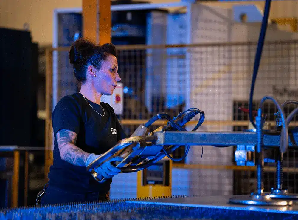Femme qui fait de la découpe laser chez Claude Industries